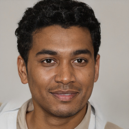 Joyful black young-adult male with short  black hair and brown eyes