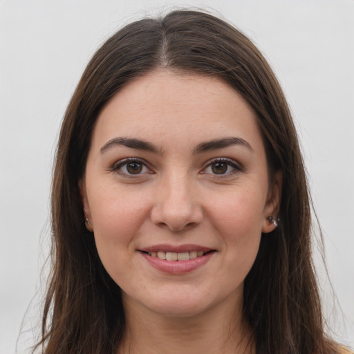 Joyful white young-adult female with long  brown hair and brown eyes