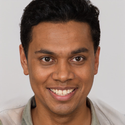 Joyful black young-adult male with short  brown hair and brown eyes