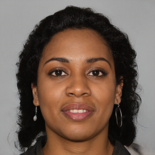 Joyful black young-adult female with long  brown hair and brown eyes