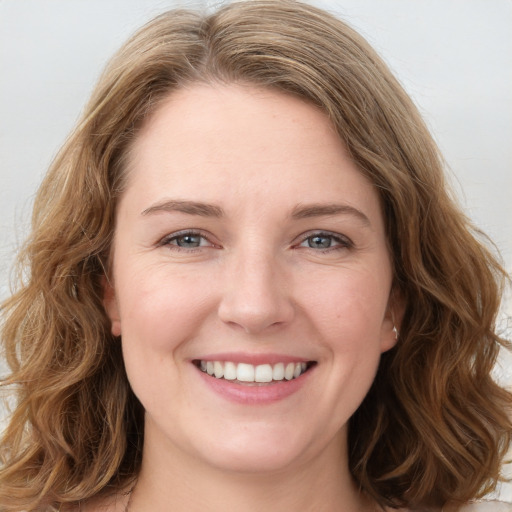 Joyful white young-adult female with long  brown hair and green eyes