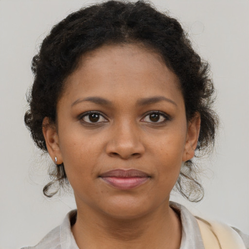 Joyful black young-adult female with medium  brown hair and brown eyes