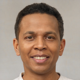 Joyful latino young-adult male with short  brown hair and brown eyes