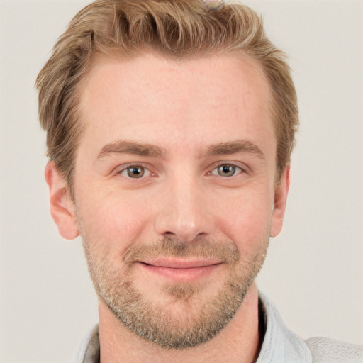 Joyful white young-adult male with short  brown hair and blue eyes