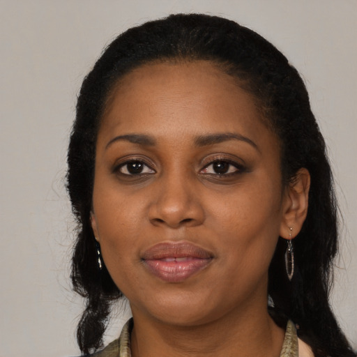 Joyful black young-adult female with long  black hair and brown eyes