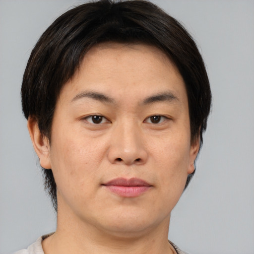 Joyful asian young-adult male with short  brown hair and brown eyes