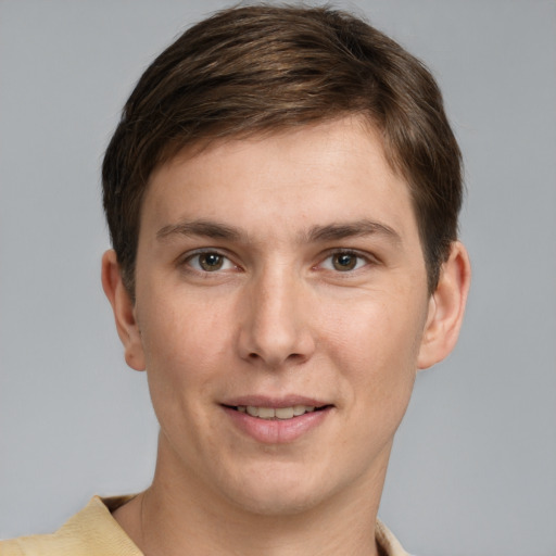 Joyful white young-adult male with short  brown hair and grey eyes