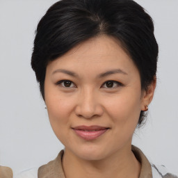 Joyful asian young-adult female with medium  brown hair and brown eyes