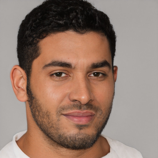Joyful latino young-adult male with short  black hair and brown eyes