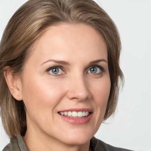 Joyful white adult female with medium  brown hair and grey eyes