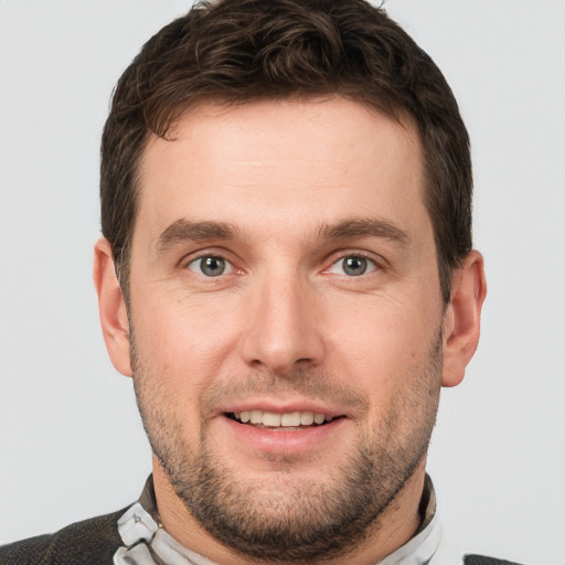 Joyful white young-adult male with short  brown hair and grey eyes