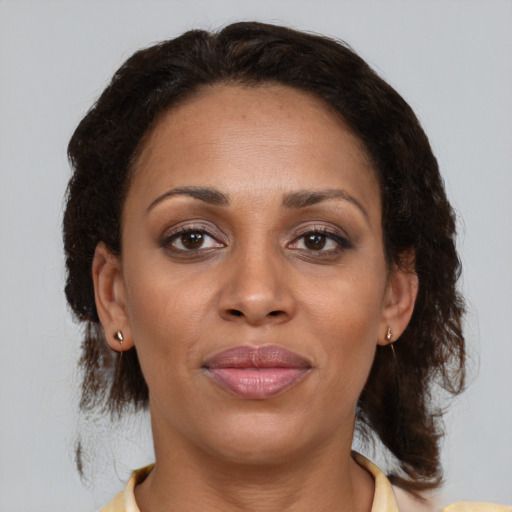 Joyful black adult female with medium  brown hair and brown eyes