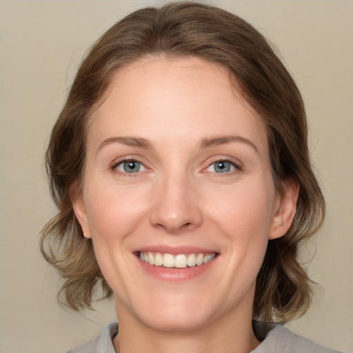 Joyful white young-adult female with medium  brown hair and green eyes