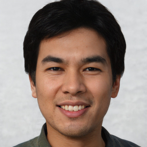 Joyful asian young-adult male with short  black hair and brown eyes