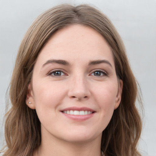 Joyful white young-adult female with long  brown hair and grey eyes