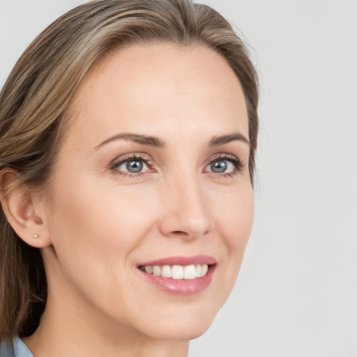 Joyful white young-adult female with long  brown hair and blue eyes