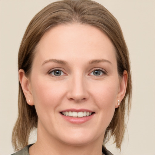 Joyful white young-adult female with medium  brown hair and grey eyes