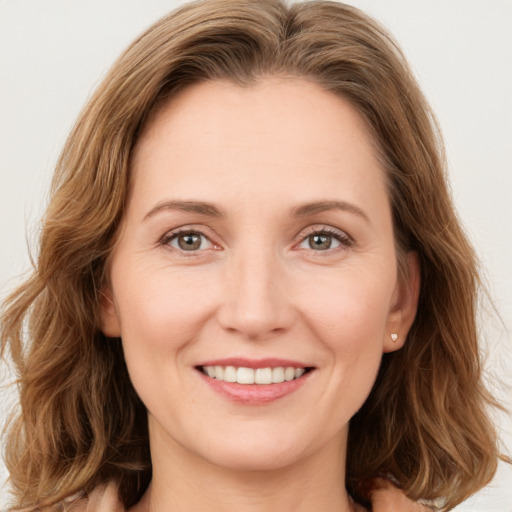 Joyful white young-adult female with long  brown hair and green eyes