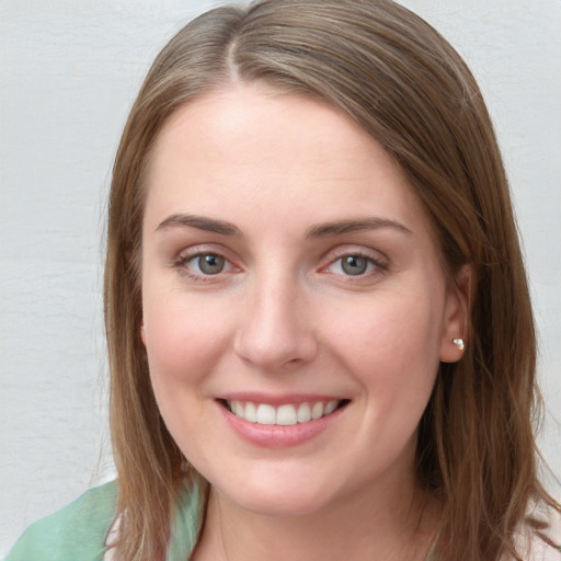 Joyful white young-adult female with long  brown hair and blue eyes