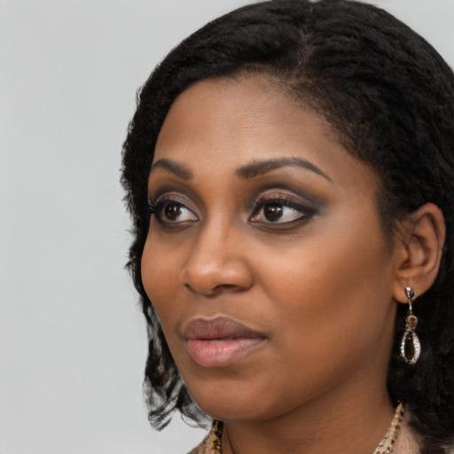 Joyful black young-adult female with long  black hair and brown eyes