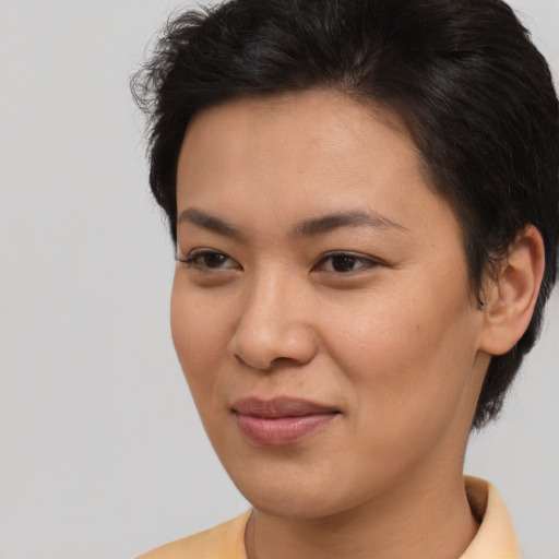 Joyful asian young-adult female with short  brown hair and brown eyes