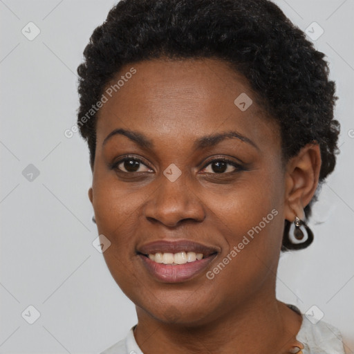 Joyful black young-adult female with short  black hair and brown eyes