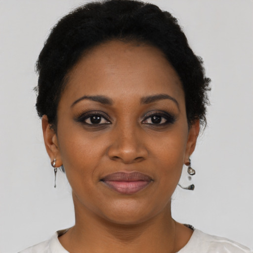 Joyful black young-adult female with short  black hair and brown eyes