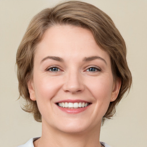 Joyful white young-adult female with medium  brown hair and green eyes