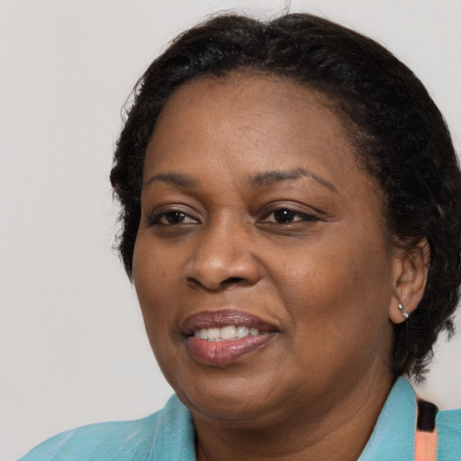 Joyful black adult female with medium  brown hair and brown eyes