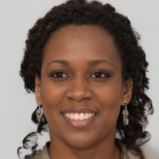 Joyful black adult female with long  brown hair and brown eyes