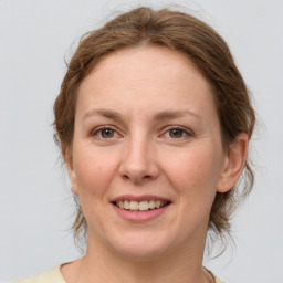 Joyful white adult female with medium  brown hair and green eyes