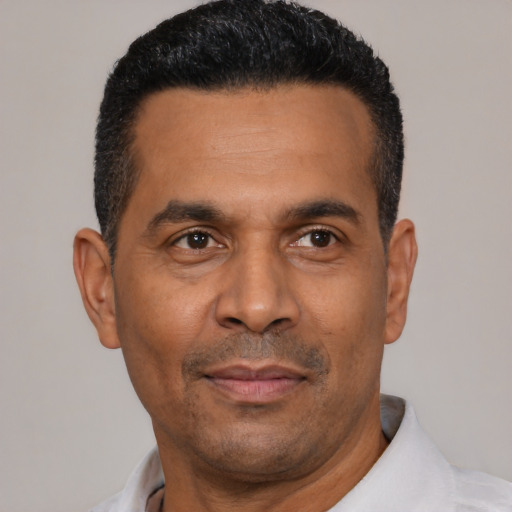 Joyful latino adult male with short  black hair and brown eyes