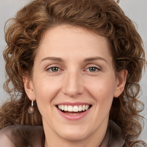 Joyful white young-adult female with long  brown hair and green eyes