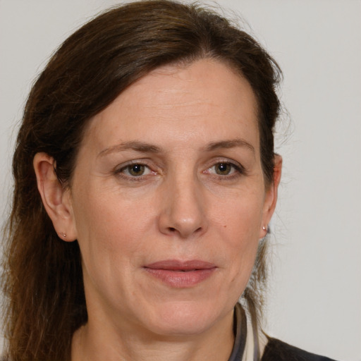 Joyful white adult female with long  brown hair and grey eyes