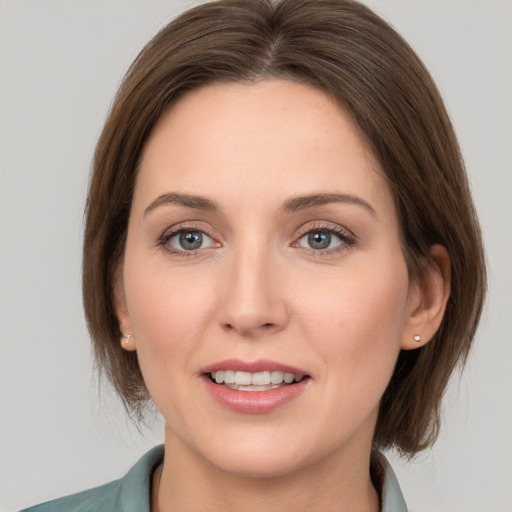 Joyful white young-adult female with medium  brown hair and grey eyes