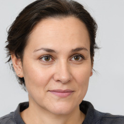 Joyful white adult female with medium  brown hair and brown eyes