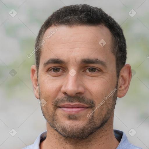 Joyful white adult male with short  black hair and brown eyes