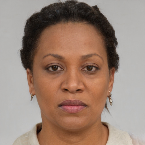 Joyful black adult female with short  brown hair and brown eyes
