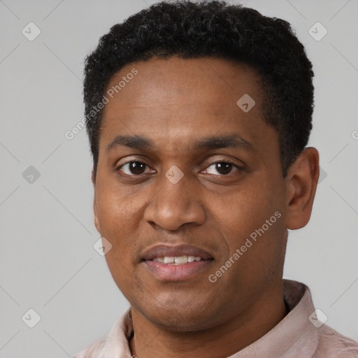 Joyful black young-adult male with short  black hair and brown eyes