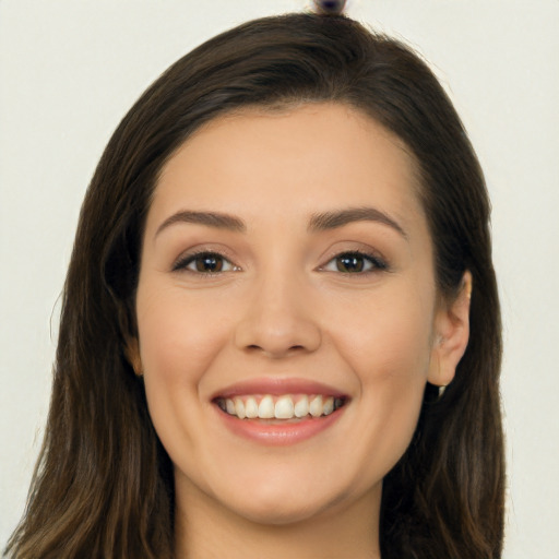 Joyful white young-adult female with long  brown hair and brown eyes