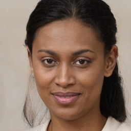 Joyful black young-adult female with long  brown hair and brown eyes