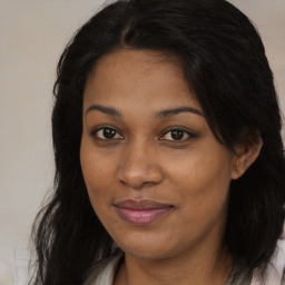 Joyful black young-adult female with long  brown hair and brown eyes