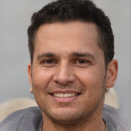 Joyful white adult male with short  brown hair and brown eyes
