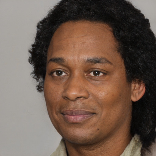 Joyful black adult male with short  black hair and brown eyes