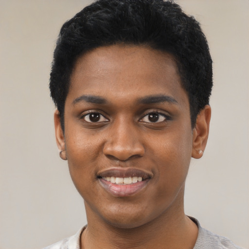 Joyful black young-adult male with short  black hair and brown eyes