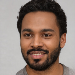 Joyful black young-adult male with short  black hair and brown eyes