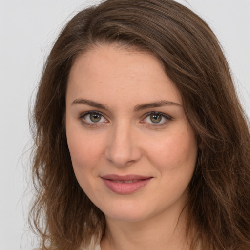 Joyful white young-adult female with long  brown hair and green eyes