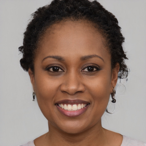 Joyful black young-adult female with short  brown hair and brown eyes
