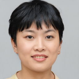 Joyful asian young-adult female with short  brown hair and brown eyes