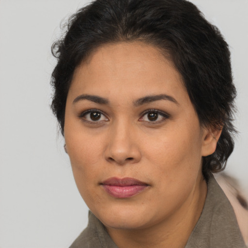Joyful latino adult female with long  brown hair and brown eyes